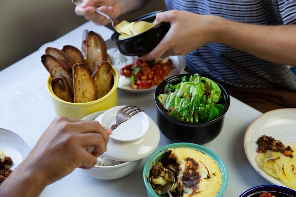 Hand-with-fork-and-food-at-table
